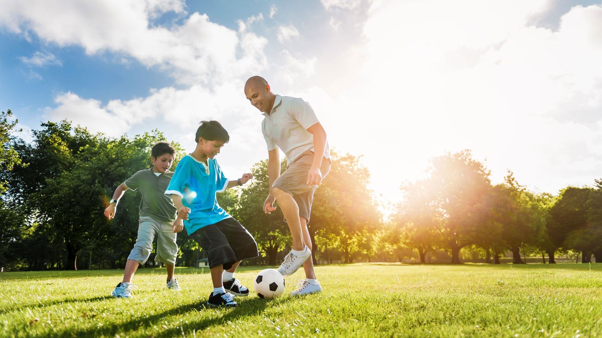 Father and sons playing soccer